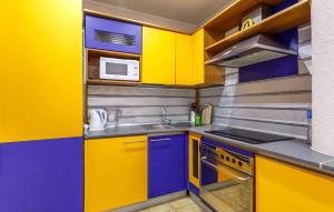 モスクワにあるFortEstate Apartment Vorontsovskiy Parkのキッチン(黄色と青色のキャビネット、電子レンジ付)