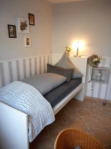 ein Schlafzimmer mit einem Bett mit einer Decke und einer Lampe in der Unterkunft Privatzimmer Spahn in Mühlheim in Mühlheim