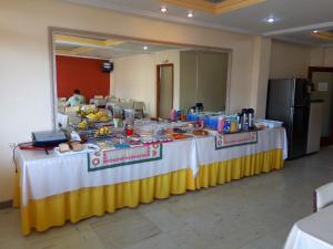 - une longue table avec de la nourriture dans une pièce dans l'établissement City Hotel PF, à Passo Fundo