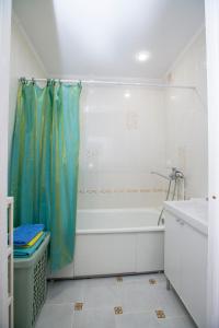 a bathroom with a tub and a shower curtain at Apartment "Уют" in Ufa
