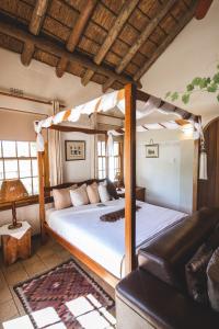 a bedroom with a canopy bed and a couch at Beausoleil in Bonnievale