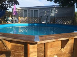 una piscina con terraza de madera y una piscina en Résidence de vacances Villa Cottage en Bréhémont