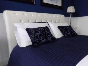 a bed with black and white pillows on it at Hs4U The Blue Charm Suite apartment in Prato