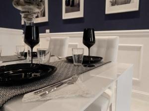 a table with a black plate and wine glasses on it at Hs4U The Blue Charm Suite apartment in Prato