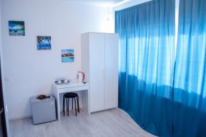 a room with a desk and a blue curtain at City Lux Villa in Bucharest