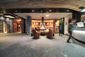 a lobby of a hotel with a person walking through it at Hotel Tirol in Ischgl