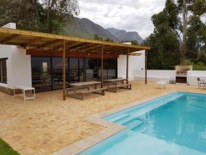 a patio with a swimming pool and a house at Oudekloof Wine Estate in Tulbagh