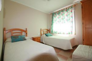 a bedroom with two beds and a window at OLIVA HOLIDAYS 1 in Oliva +32 photos