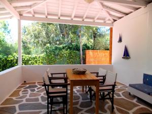 a dining room with a table and chairs and a large window at Skiathos Driades in Koukounaries