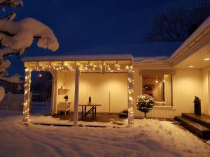 een patio met 's nachts verlichting in de sneeuw bij Holiday home close to forest, lake and skiing in Ulricehamn