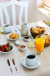 a table topped with plates of food and cups of coffee at Divina Casona Posada Boutique in San Rafael