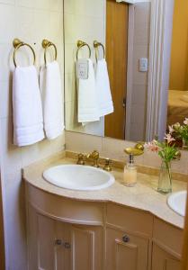 y baño con lavabo, espejo y toallas. en Divina Casona Posada Boutique en San Rafael