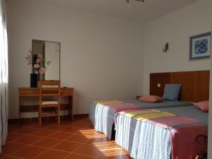 阿爾布費拉的住宿－Apartamentos Colina do Mar Downtown Albufeira，一间卧室配有两张床、一张桌子和一面镜子