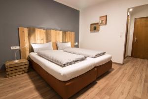 een slaapkamer met een groot bed met een houten hoofdeinde bij Mellow Mountain Hostel in Ehrwald