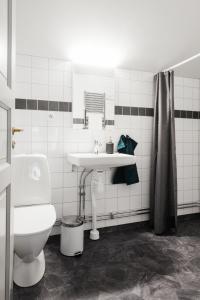 a white bathroom with a sink and a toilet at Hilma Winblads Bed & Breakfast in Linköping