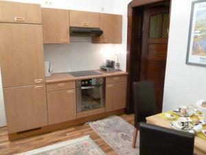 cocina con armarios de madera y mesa de madera con mesa en Villa Charlotte en Bad Liebenstein