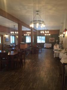 uma sala de jantar com mesas e cadeiras e um lustre em Spruce Hill Resort & Spa em 108 Mile Ranch