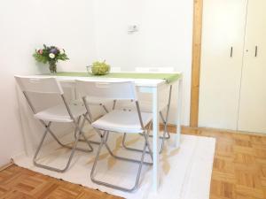 a white table with two white chairs and a green counter at Apartment Maya's in Zagreb