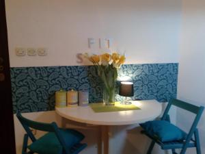 een tafel met een vaas met bloemen en twee stoelen bij Apartment Optimist/City Break in Split
