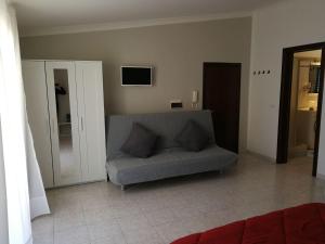 a living room with a couch and a tv at XXI Agosto Home in Reggio di Calabria