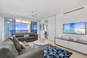 a living room with a couch and a tv at Soul Beachfront Apartments - HR Surfers Paradise in Gold Coast