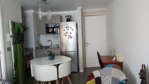 a kitchen with a refrigerator and a table in it at Edificio One in Iquique +6 photos