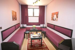 ein Zimmer mit einem roten Sofa und einem Tisch in der Unterkunft INOU Hotel in Agadir
