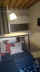 een woonkamer met een blauwe bank en een tafel bij Cinquelune Apartment in Rosà