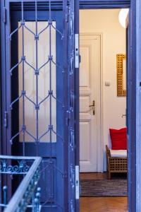 a blue door in a room with a red bench at Andrassy 91 Apartment in Budapest