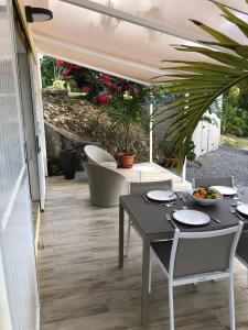 a patio with a table and chairs and toilets at Jolibois Lodge & Spa in Le Gosier