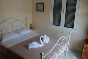 a bedroom with a bed with a white swan on it at Prosilia Guesthouse in Prosília