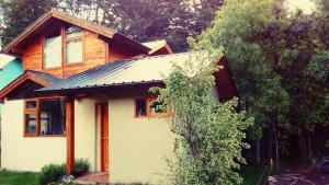 a house with a metal roof on top of it at Cabaña Rufus in Lago Puelo