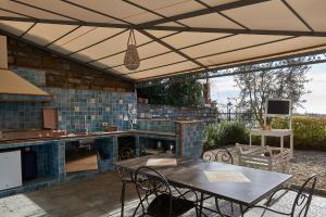 eine Terrasse mit einem Tisch und Stühlen unter einem Dach in der Unterkunft Agriturismo Le Girandole in Diano Marina