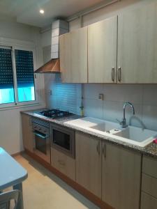 uma cozinha com um lavatório e um fogão em Loft Aziz em Tunes