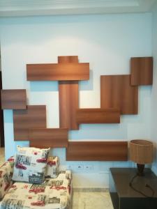 a bedroom with a bed and wooden shelves at Loft Aziz in Tunis