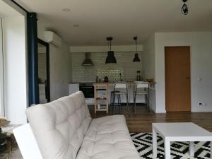a living room with a white couch and a kitchen at Dru-Sky in Druskininkai