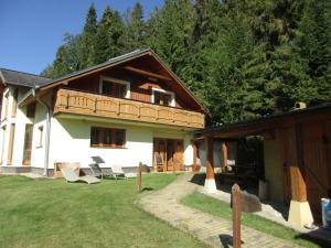 a house with a porch and a patio in the yard at Villa Cechy in Hnilčík