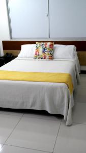 a bedroom with a bed with a yellow blanket at Hotel Sama in Montería +9 photos