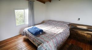 1 dormitorio con 1 cama con manta y ventana en Cabañas Aguaflorida en Gualeguay