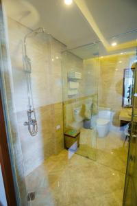 a bathroom with a shower and a toilet and a sink at Grand Hotel in Hòa Bình