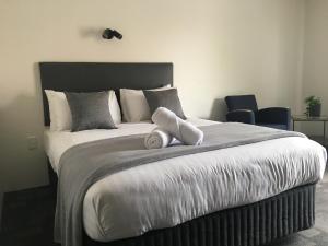 a bedroom with a bed and a night stand at Hotel Clipper in Rockingham
