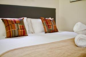 a bed with a white comforter and pillows at Hotel Clipper in Rockingham