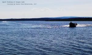 ein Boot in einem großen Wasserkörper in der Unterkunft Caravan INN in Quesnel