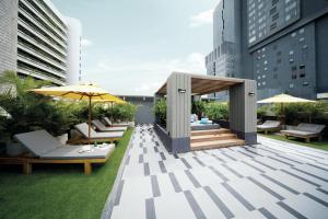 a rooftop patio with chairs and umbrellas on a building at Kritthai Residence in Bangkok