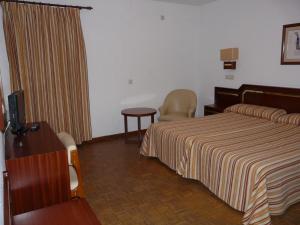 
a hotel room with a bed and a television at Hotel Santa María in Palos de la Frontera
