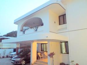 duży biały dom z balkonem i samochodem w obiekcie Corner Stay Serviced Apartment-Racecourse w mieście Coimbatore