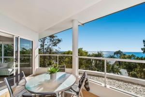 a dining room table with a view of the ocean at The Lookout Resort Noosa in Noosa Heads