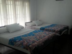 two beds sitting next to each other in a room at See Fox Hill Resort in Bandarawela