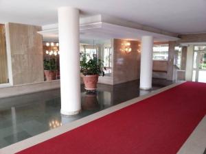 un gran vestíbulo con una alfombra roja y columnas en Appartement Dolce Vita en Cagnes-sur-Mer