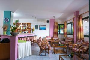 a room with chairs and a bar in a restaurant at Golden Sun Holiday Apts by Estia in Hersonissos